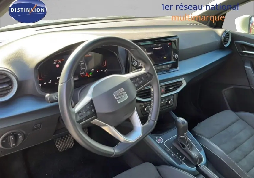 Vue intérieure du poste de conduite de la SEAT Arona 2025, volant cuir et tableau de bord numérique, ambiance noire élégante.
