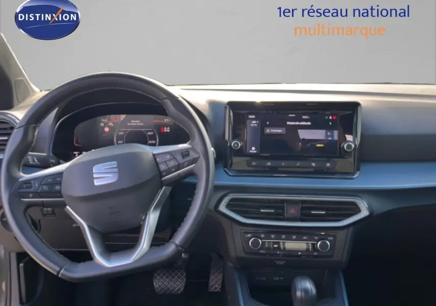 Vue intérieure frontale du tableau de bord du SEAT Arona gris magnétique, avec volant multifonction et écran tactile central.
