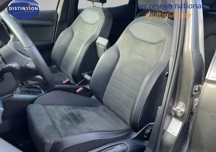 Vue intérieure côté conducteur du SEAT Arona gris métallique, sièges en cuir et alcantara avec surpiqûres blanches.