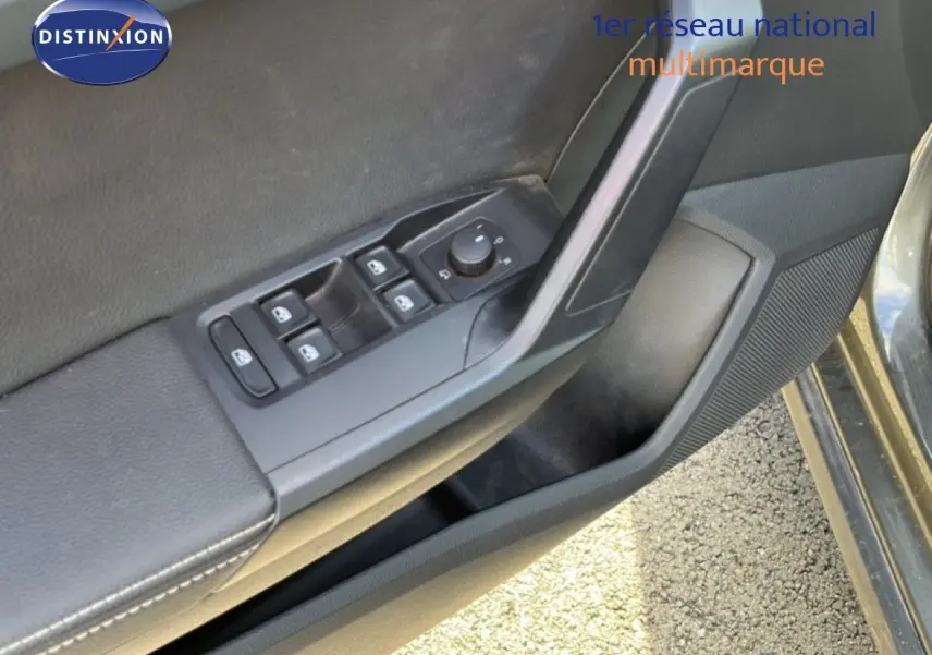 Détail de la porte avant gauche du SEAT Arona gris métallique, montrant les commandes des vitres et rétroviseurs.