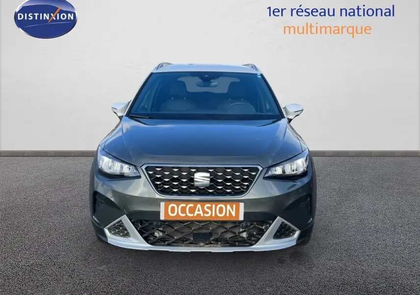 Vue frontale d'un SEAT Arona gris magnétique avec calandre noire et détails argentés, sur fond neutre.