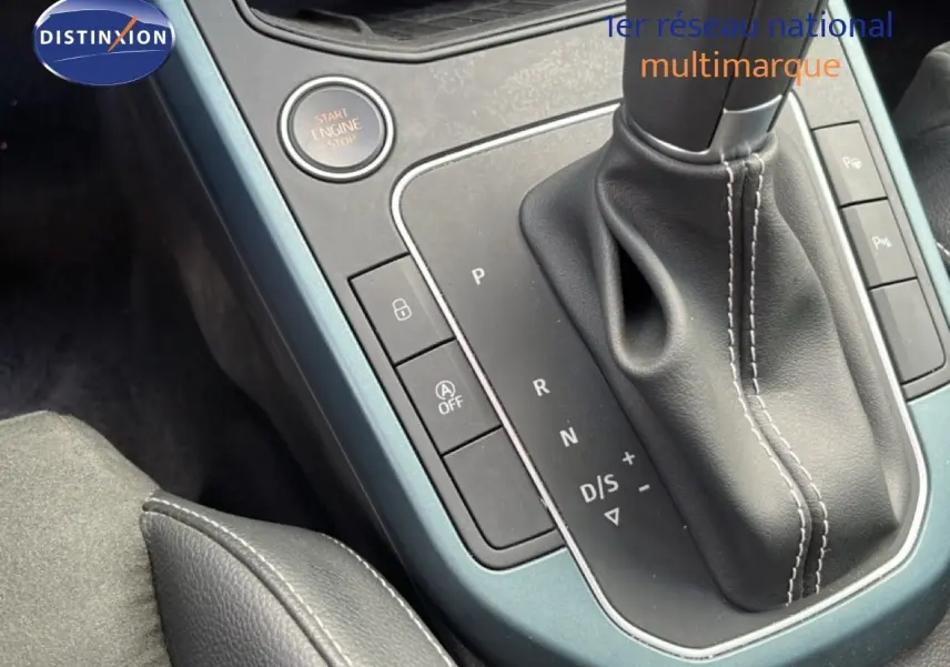 Gros plan sur la console centrale de la SEAT Arona 2025, montrant le levier de vitesse en cuir et les boutons de commande.