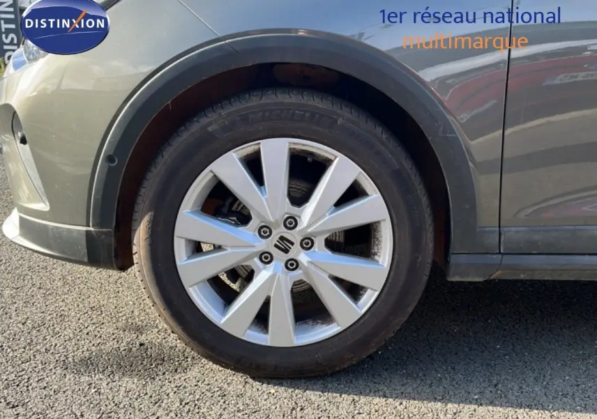 Gros plan sur la roue avant gauche d’un SEAT Arona gris magnétique métal avec jante alliage 17 pouces.
