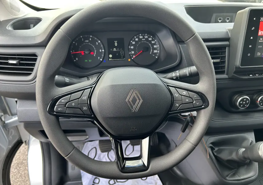 Vue rapprochée du volant noir du Renault Trafic Fourgon L1H1 2026 avec commandes intégrées et tableau de bord digital.