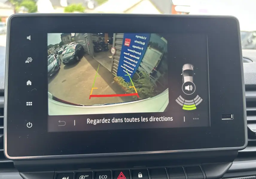 Affichage caméra de recul du Renault Trafic blanc, vue arrière avec lignes de guidage colorées sur écran intérieur.