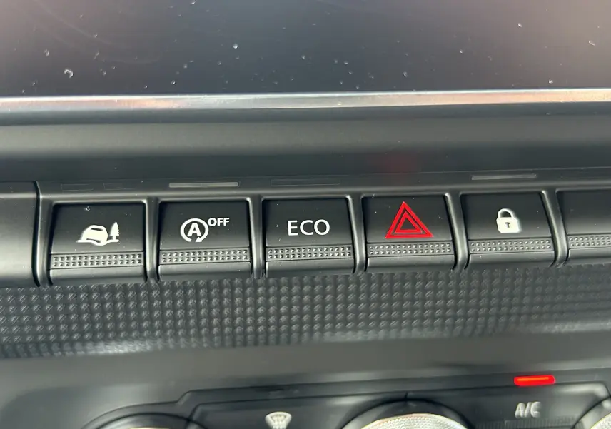 Gros plan sur les boutons de commande du tableau de bord du Renault Trafic Fourgon blanc, avec fonction ECO et alerte.