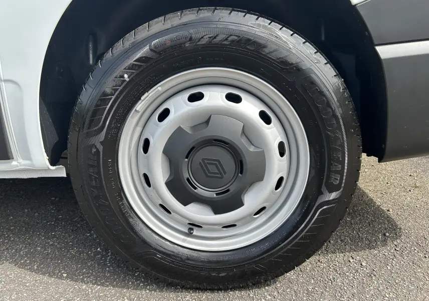 Gros plan sur la roue avant droite du Renault Trafic blanc, jante acier avec logo Renault au centre.