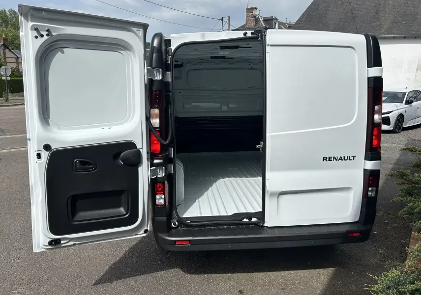Vue arrière du Renault Trafic blanc avec portes battantes ouvertes montrant l’espace de chargement vide.