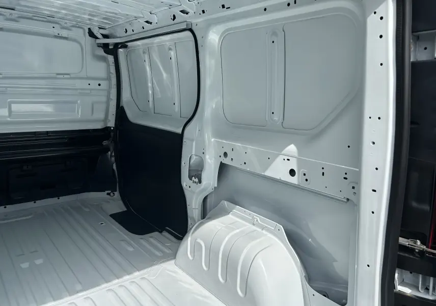 Intérieur du fourgon Renault Trafic blanc vu de l’arrière, montrant la cloison complète tôlée et l’espace de chargement vide.