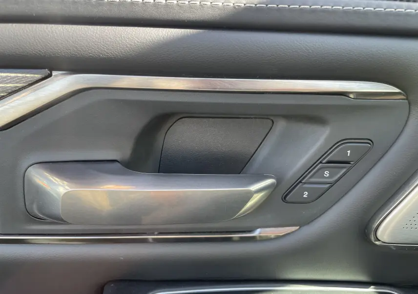 Poignée de porte intérieure côté gauche du Dodge RAM 1500 blanc nacré avec boutons de mémoire des sièges.