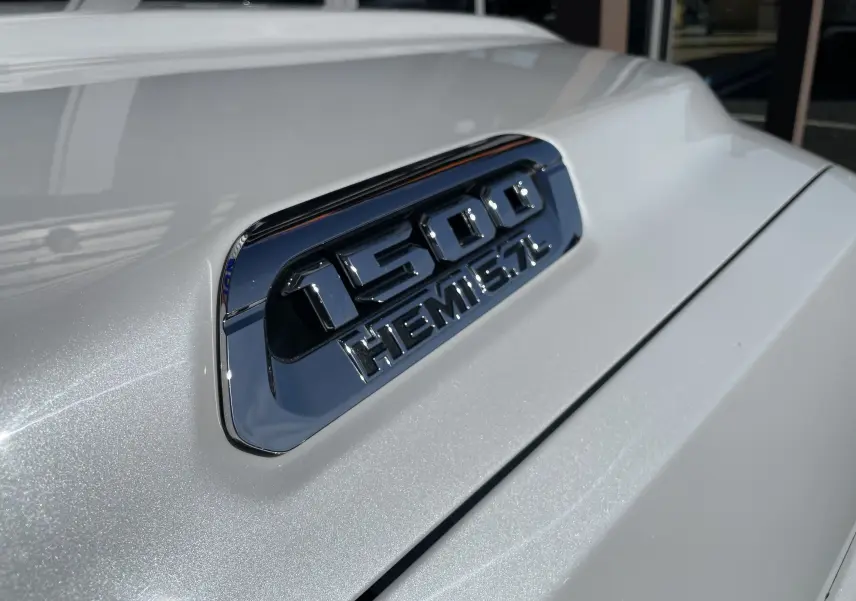 Gros plan sur l'insigne 1500 HEMI 5.7L sur la carrosserie blanc nacré du Dodge RAM 1500 2020.
