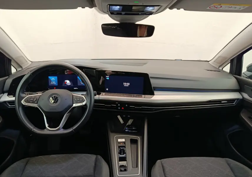 Vue intérieure avant de la Volkswagen Golf 1.0 eTSI Life Business 2022, tableau de bord moderne avec écran tactile et volant cuir noir.