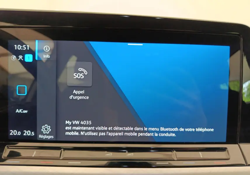 Écran tactile central affichant l'option d'appel d'urgence dans l'habitacle d'une Volkswagen Golf gris foncé.