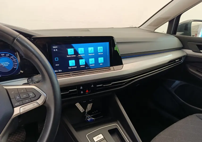 Intérieur de Volkswagen Golf 2022 gris foncé, vue tableau de bord avec écran tactile central et volant cuir multifonctions.