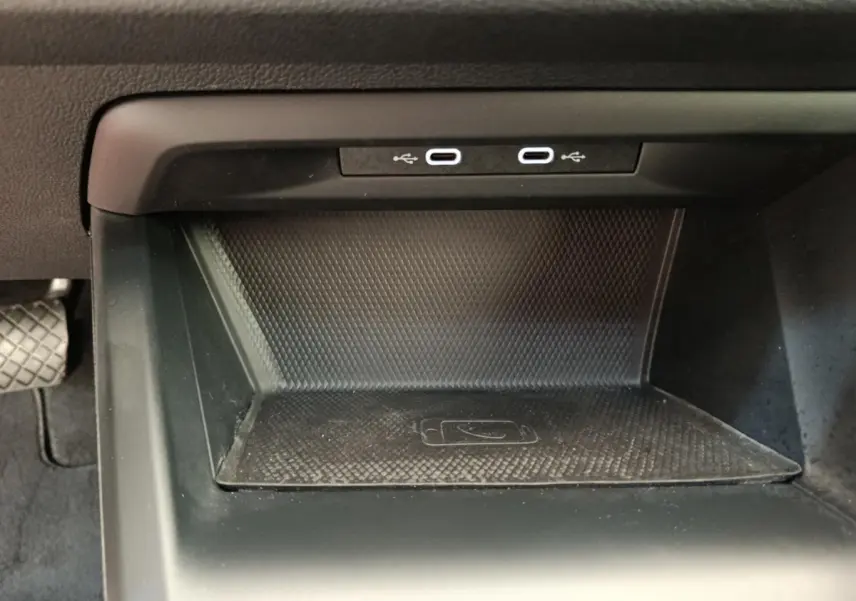 Espace de recharge sans fil et double port USB-C dans la console centrale d'une Volkswagen Golf gris foncé 2022.