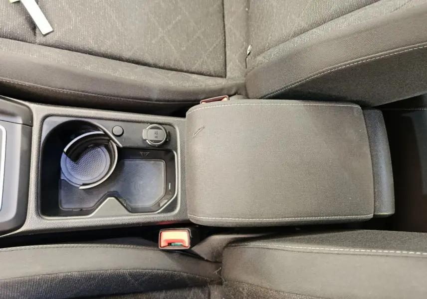 Gros plan sur la console centrale et accoudoir en tissu gris foncé de la Volkswagen Golf 2022.