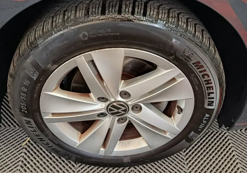 Gros plan sur la roue avant droite d'une Volkswagen Golf gris foncé avec jante alliage et pneu Michelin hiver.