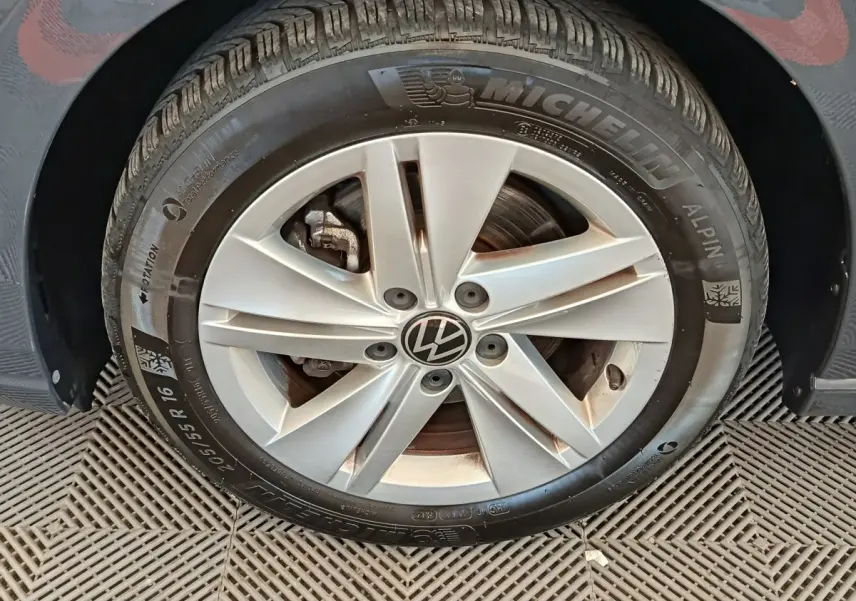 Gros plan sur la roue avant gauche d'une Volkswagen Golf gris foncé avec jante alliage et pneu Michelin hiver.