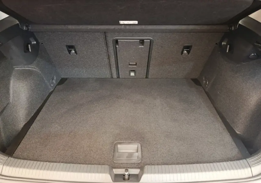 Coffre spacieux gris foncé de la Volkswagen Golf 2022, vue intérieure avec banquette rabattable et trappe à ski.
