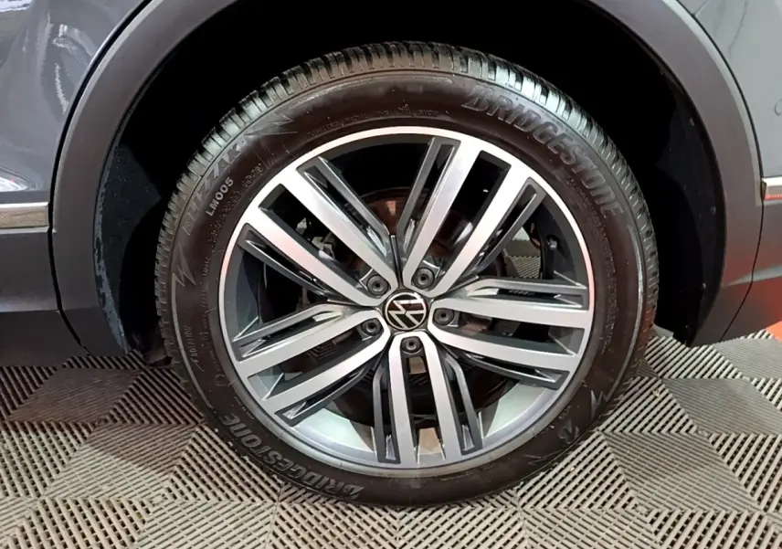 Gros plan sur la roue avant droite gris clair du Volkswagen Tiguan 2.0 TDI 150 DSG7 Elegance avec jante alliage et pneu Bridgestone.