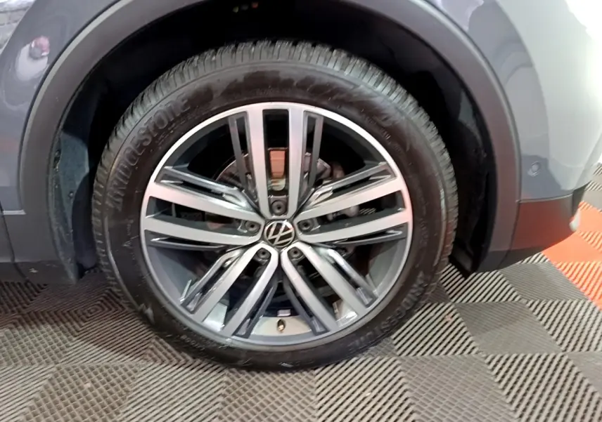 Gros plan sur la roue avant droite gris clair du Volkswagen Tiguan 2.0 TDI 150 DSG7 Elegance 2022 avec jante alliage.