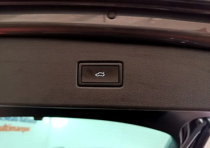 Bouton d'ouverture électrique du coffre sur la partie intérieure du hayon du Volkswagen Tiguan gris clair 2022.