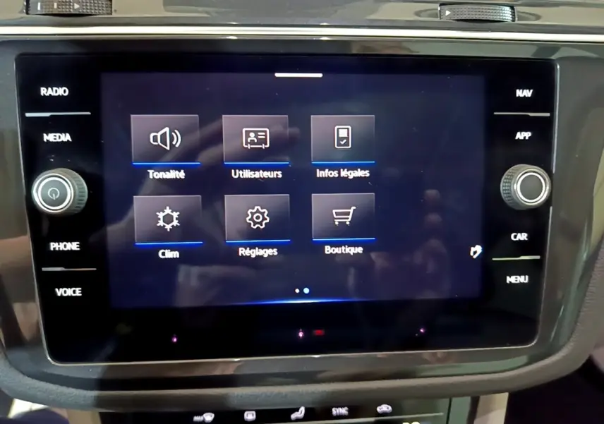 Écran tactile central du Volkswagen Tiguan gris clair 2022 affichant menu tonalité, clim, réglages et boutique.