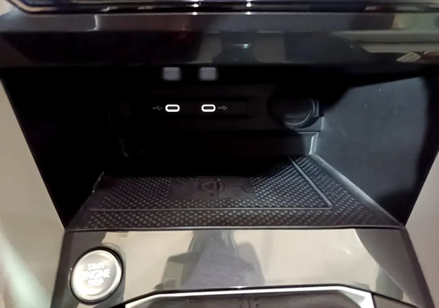 Gros plan sur la console centrale noire du Volkswagen Tiguan 2022, avec ports USB-C et bouton démarrage.