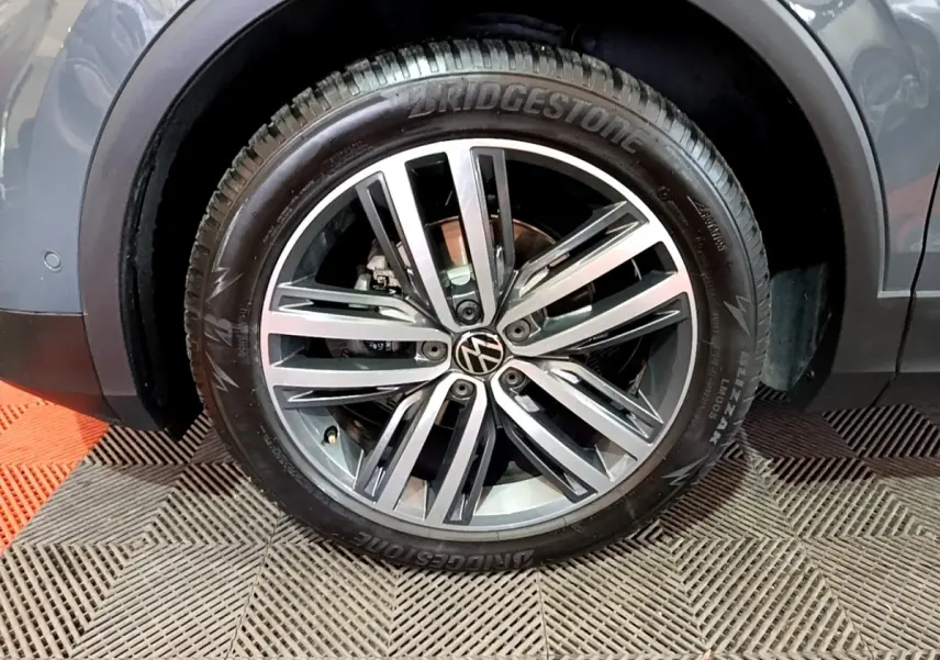 Gros plan sur la roue avant gauche gris clair du Volkswagen Tiguan 2.0 TDI avec jante alliage et pneu Bridgestone.
