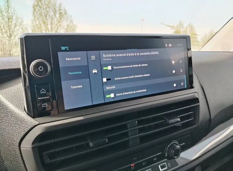 Vue rapprochée de l'écran tactile central du tableau de bord du Citroën Jumpy gris titane, affichant les aides à la conduite.