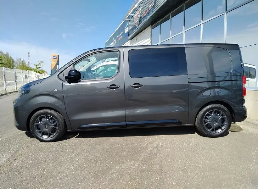 Vue latérale droite d’un Citroën Jumpy Cabine Approfondie gris titane avec portes coulissantes et roues tôlées noires 17 pouces.