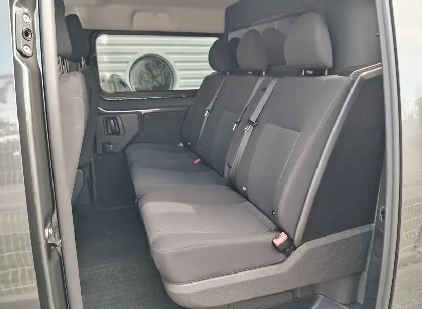 Vue intérieure côté droit des sièges arrière gris foncé du Citroën Jumpy Cabine Approfondie 2025 avec ceinture de sécurité.