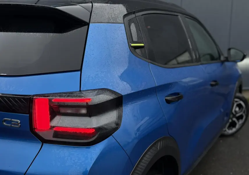 Vue 3/4 arrière droite d'une Citroën C3 2025 Bright Blue avec toit noir Perla Nera et feux arrière LED 3D.