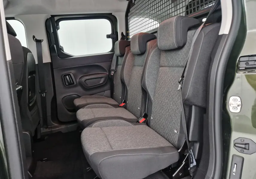 Vue latérale intérieure du combo life vert sirkka montrant les trois sièges individuels arrière et la grille de séparation.