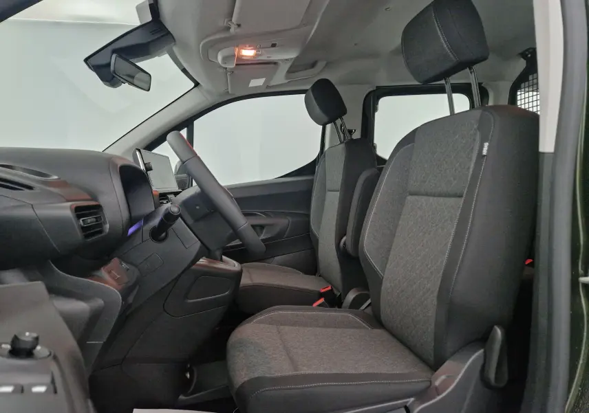 Vue intérieure côté gauche de l'Opel Combo Life vert Sirkka, montrant les sièges avant gris et la grille de séparation arrière.