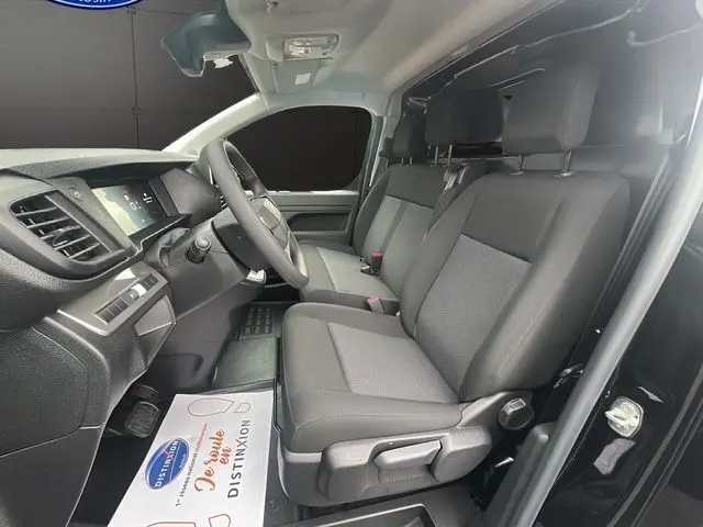 Intérieur avant du Citroën Jumpy noir 2025, montrant les sièges tissu noir et le tableau de bord moderne côté conducteur.