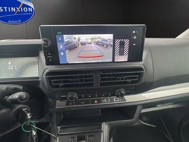 Intérieur du Citroën Jumpy 2025 noir, vue sur le tableau de bord avec écran affichant la caméra de recul et commandes climatisation.