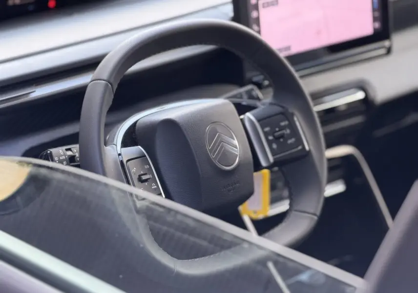 Gros plan sur le volant noir de la Citroën C3 Turbo 100 Max avec écran tactile et commandes intégrées.
