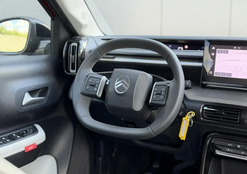 Vue intérieure centrée sur le volant multifonction noir de la Citroën C3 2025 avec écran tactile GPS à droite.