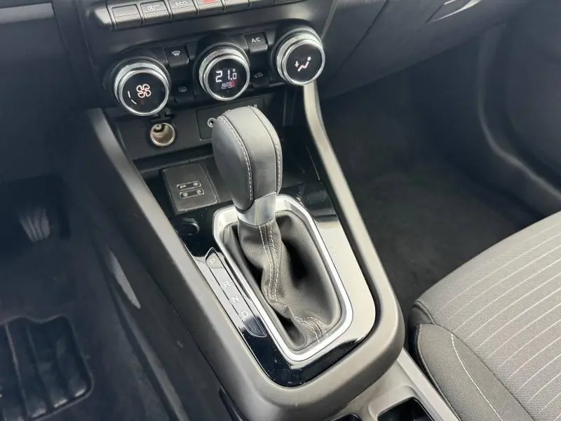 Gros plan sur la console centrale du Renault Arkana 2025 avec levier de boîte automatique et commandes de climatisation.