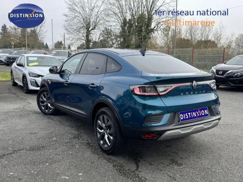 Vue 3/4 arrière droite d'un Renault Arkana bleu Zanzibar 2025 avec feux arrière reliés par un bandeau lumineux.