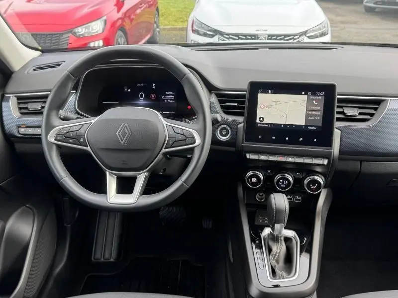 Vue intérieure frontale du tableau de bord et volant du Renault Arkana 2025, avec écran tactile et commandes modernes.
