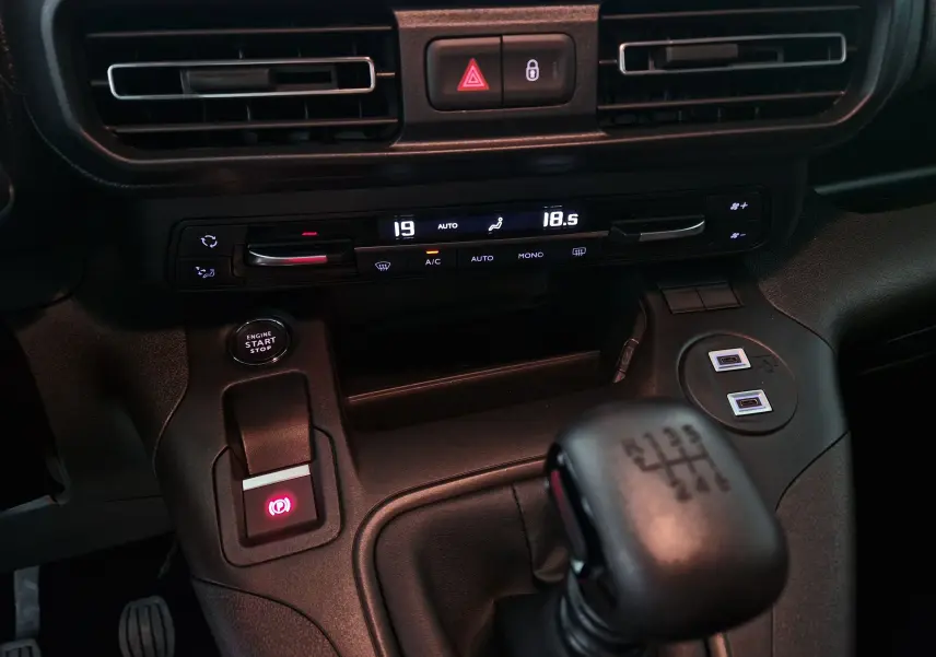 Vue rapprochée de la console centrale de l'Opel Combo Life 2025 avec boîte manuelle et commandes climatisation digitales.