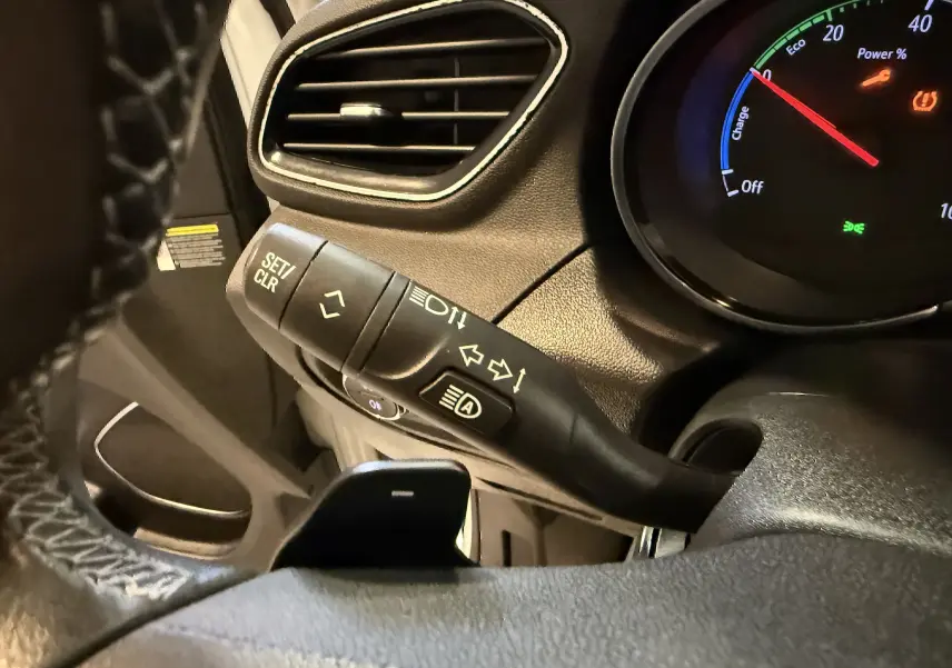 Gros plan sur la manette de clignotant et le compteur digital du tableau de bord d’un Opel Grandland X blanc.