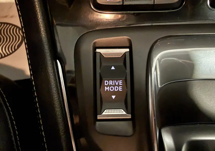 Gros plan sur le bouton Drive Mode de la console centrale noire de l’Opel Grandland X hybride rechargeable.