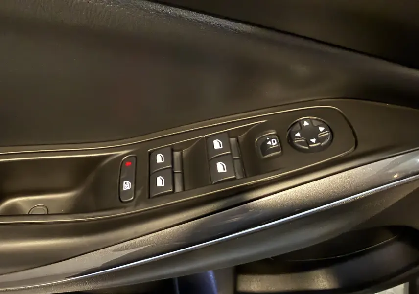 Gros plan sur les commandes de lève-vitres et réglage des rétroviseurs côté conducteur d’un Opel Grandland X 1.6 Hybrid Turbo blanc.