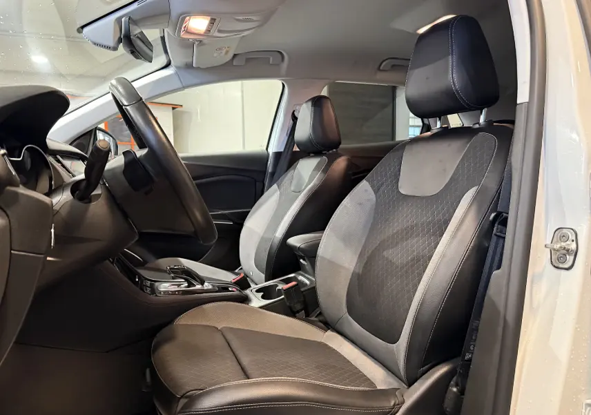 Vue intérieure côté gauche de l’Opel Grandland X blanc, montrant les sièges avant en cuir noir et tissu gris.