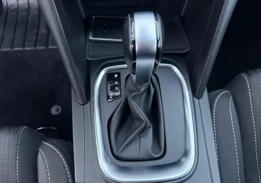 Vue rapprochée de la commande de boîte automatique de la Renault Mégane Business, avec cuir noir et coutures blanches.