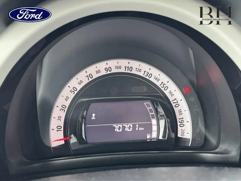 Vue rapprochée du compteur de vitesse numérique d'une Renault Twingo rouge Flamme, affichant 70 701 km.