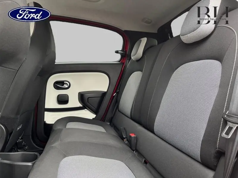 Vue intérieure arrière côté gauche de la Renault Twingo Rouge Flamme 2019, montrant les sièges et la portière.